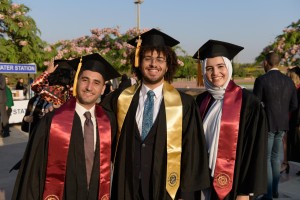 graduating_students_are_smiling_to_the_camera_in_their_commencement_in_the_garden.jpg